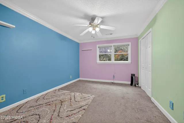 an empty room with windows and fan