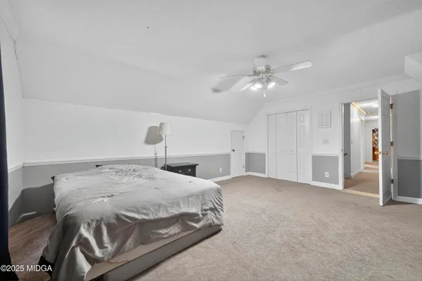 a bedroom with a bed and a ceiling fan