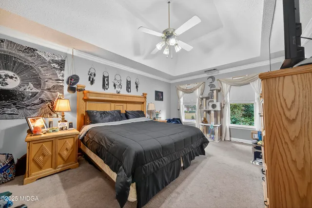 a bedroom with a large bed and a chandelier