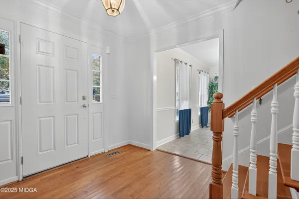 a view of a hallway with wooden floor and staircase