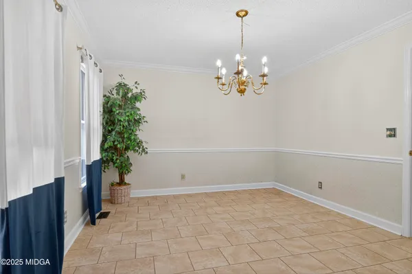 a view of a room with a chandelier and potted plants