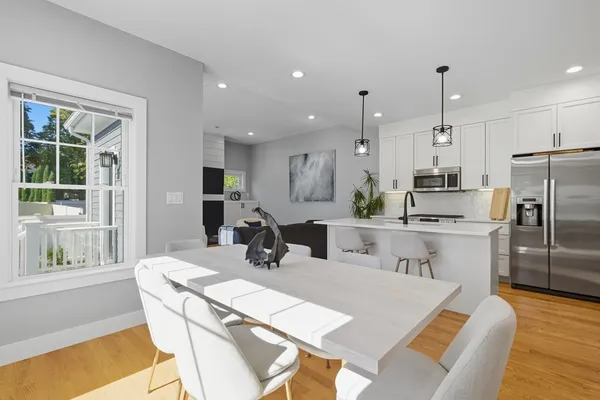 a kitchen with stainless steel appliances a dining table chairs and granite counter tops