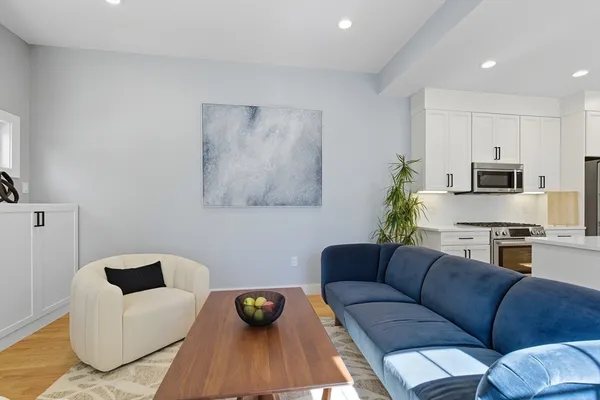 a living room with stainless steel appliances furniture and a couch