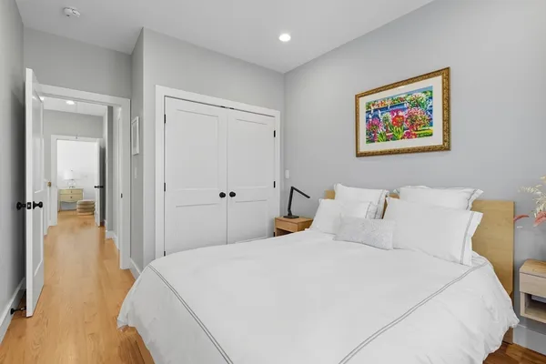 a bedroom with bed and a painting on the wall