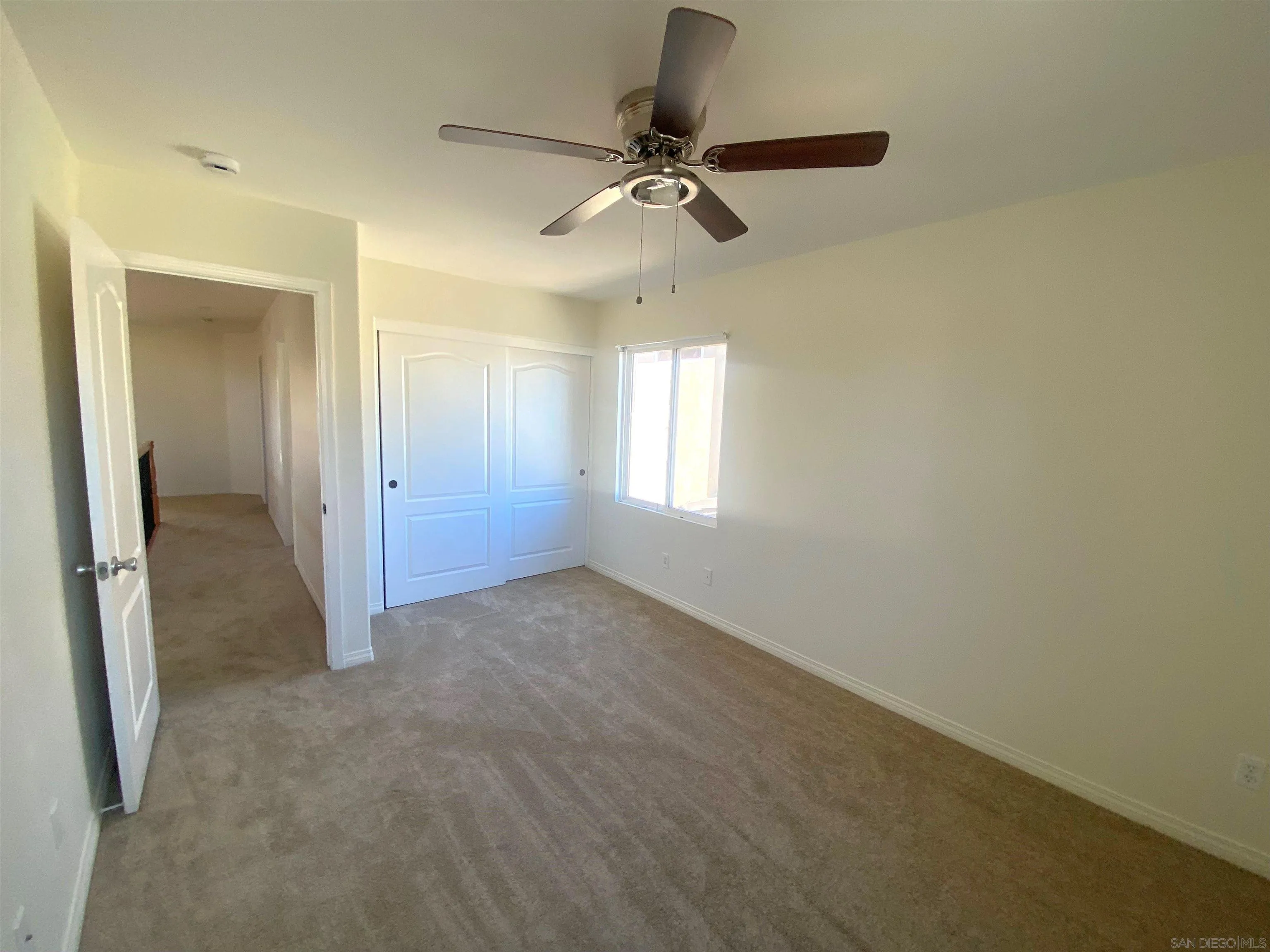 5517 Rabbit Ridge Road San Diego, CA 92130 - Photo 16 of 20 an empty room that has a window and a ceiling fan