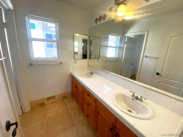 a bathroom with a double vanity sink and a mirror