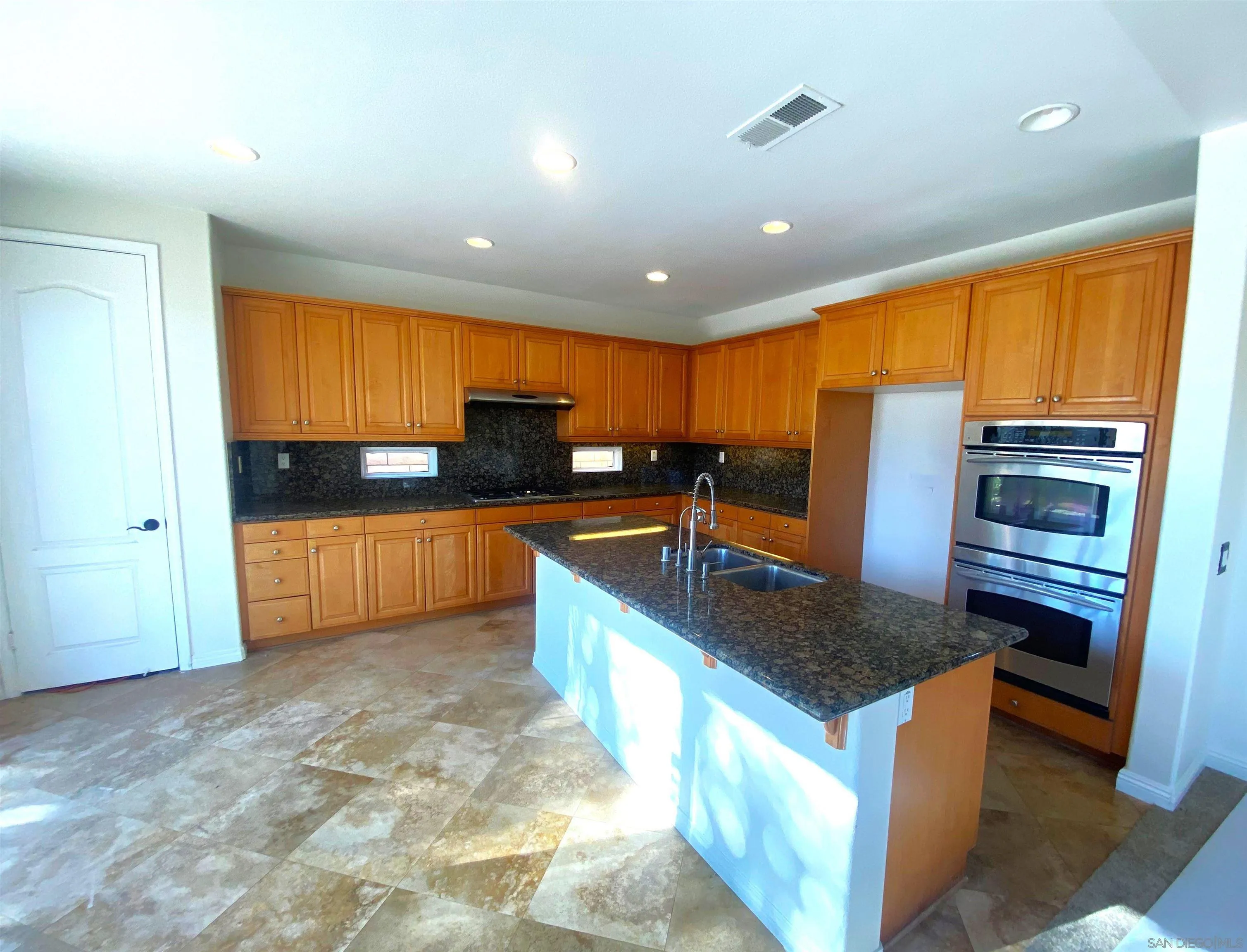 5517 Rabbit Ridge Road San Diego, CA 92130 - Photo 7 of 20 a kitchen with stainless steel appliances granite countertop sink stove and refrigerator