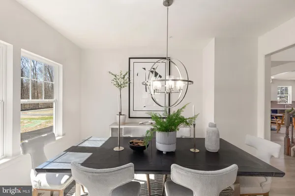 a dining room with furniture a potted plant and a chandelier