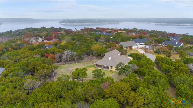 an aerial view of a house with a yard and lake view