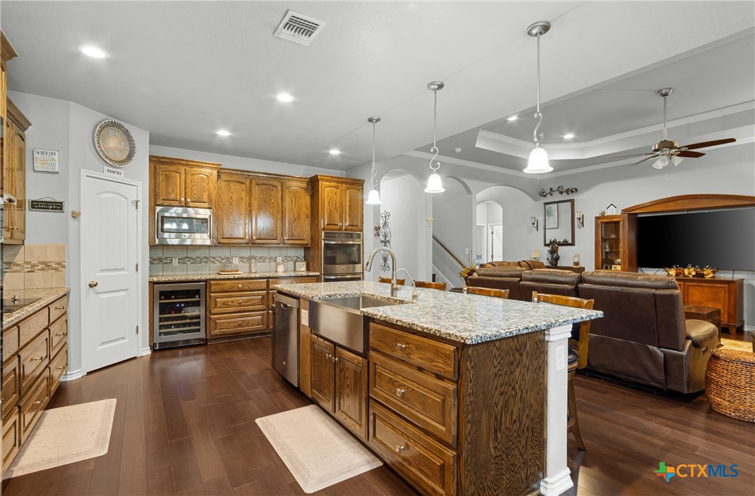 16017 Toby Court Temple, TX 76502 - Photo 11 of 33 a large kitchen with stainless steel appliances kitchen island granite countertop a stove a sink a refrigerator and a granite counter tops with white cabinets