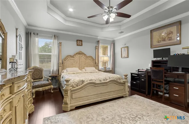 a bedroom with a bed dresser and wooden floor