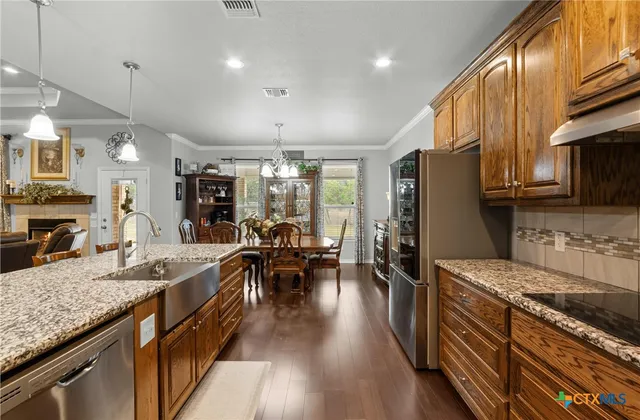 a kitchen with granite countertop lots of counter top space a sink appliances and cabinets