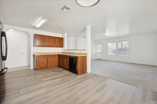 a view of a kitchen with a sink a stove top oven and refrigerator