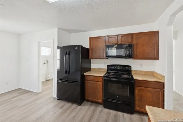 a kitchen with a stove a refrigerator and a microwave