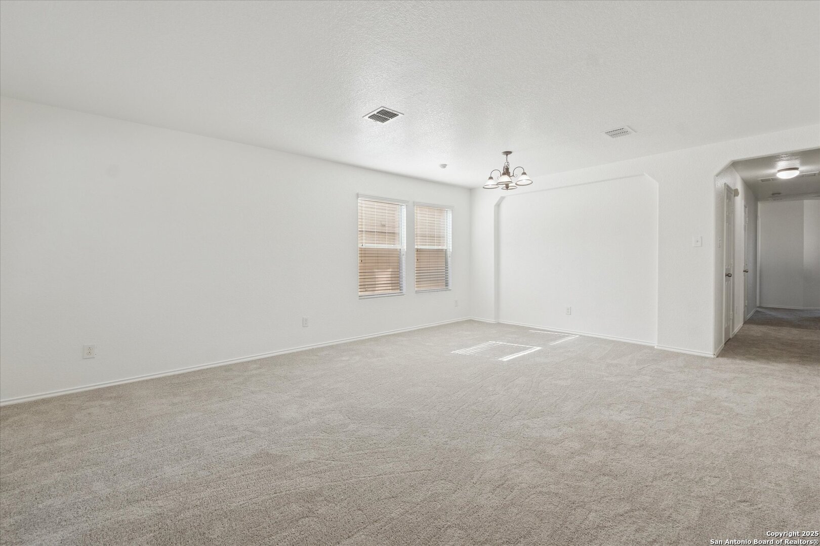 9219 Hanover Cove Converse, TX 78109 - Photo 5 of 46 an empty room with windows and chandelier fan