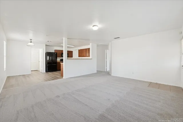 a view of a big room with wooden floor and windows