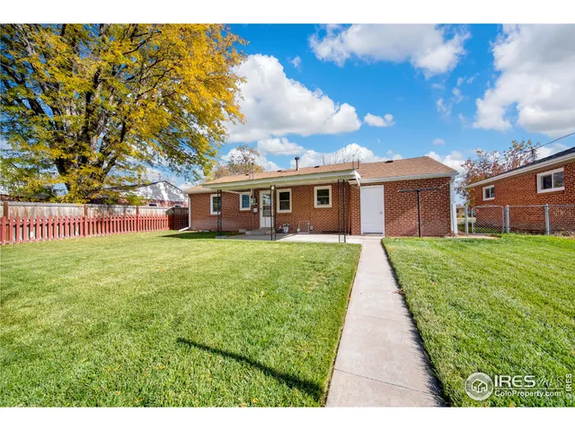 a view of a house with a big yard and large trees