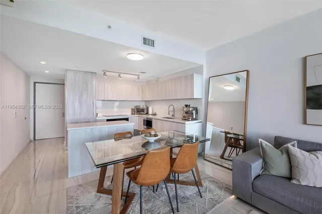 a kitchen with cabinets stainless steel appliances and wooden floor
