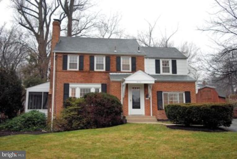a front view of a house with a yard and trees