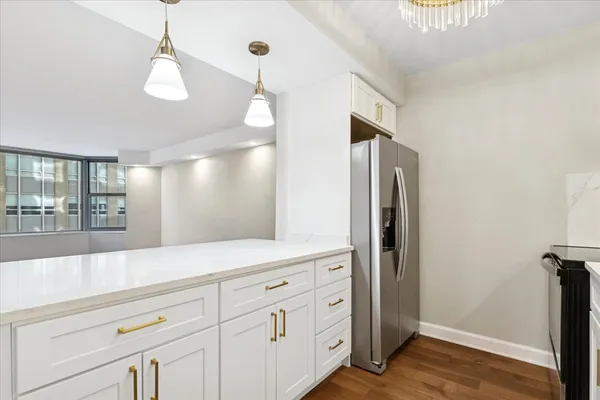 a view of a kitchen with refrigerator and wooden floor
