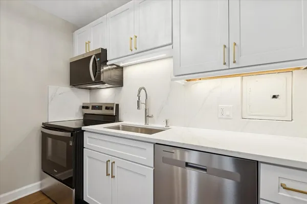 a kitchen with stainless steel appliances a sink stove and microwave