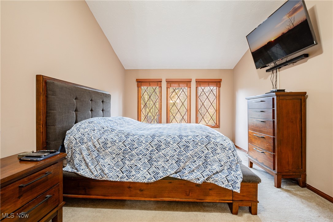 6743 Cedar Ridge Trail Clinton, OH 44216 - Photo 26 of 42 Bedroom featuring light colored carpet and vaulted ceiling