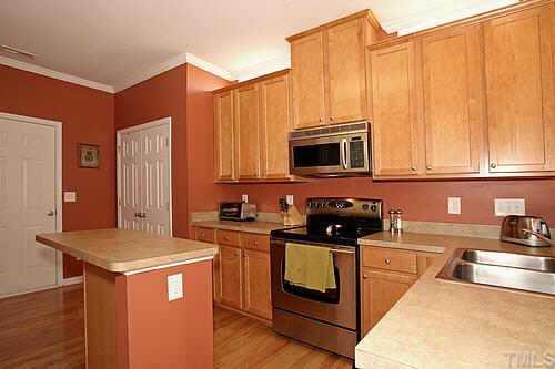 8345 Tie Stone Way Raleigh, NC 27613 - Photo 4 of 12 a kitchen with stainless steel appliances granite countertop a stove a sink and a microwave