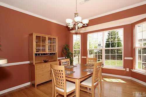 8345 Tie Stone Way Raleigh, NC 27613 - Photo 6 of 12 a dining room with furniture a chandelier and wooden floor