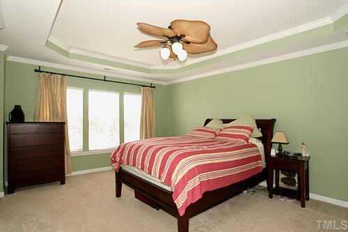 8345 Tie Stone Way Raleigh, NC 27613 - Photo 7 of 12 a bedroom with a bed and a ceiling fan