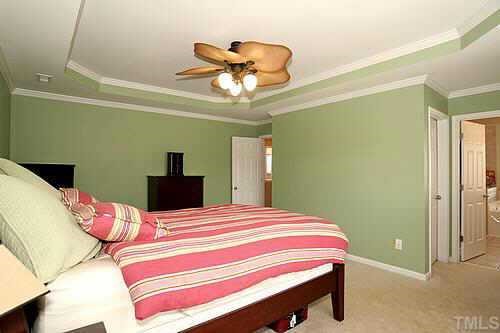 8345 Tie Stone Way Raleigh, NC 27613 - Photo 8 of 12 a bedroom with a bed and a chandelier