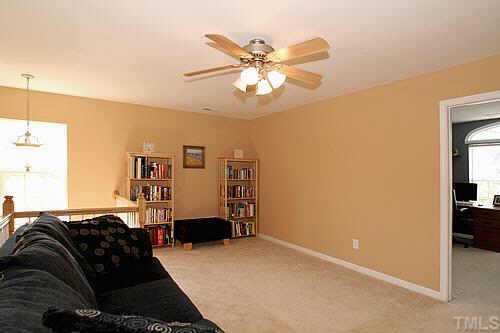 8345 Tie Stone Way Raleigh, NC 27613 - Photo 10 of 12 a bedroom with a bed and a chandelier