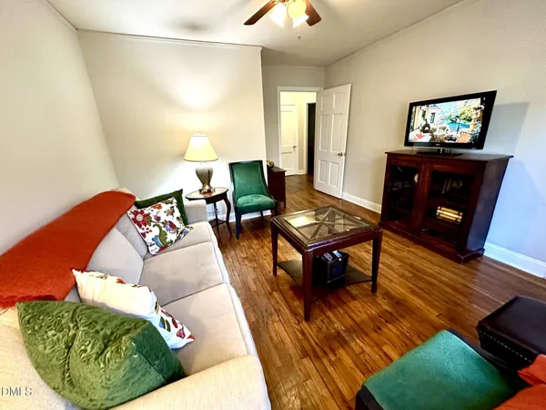 a living room with furniture and a wooden floor