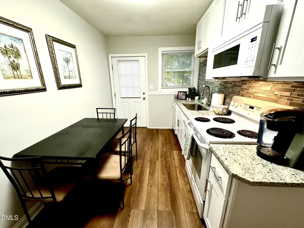 a kitchen with stainless steel appliances granite countertop a stove a sink dishwasher and a microwave with wooden floor