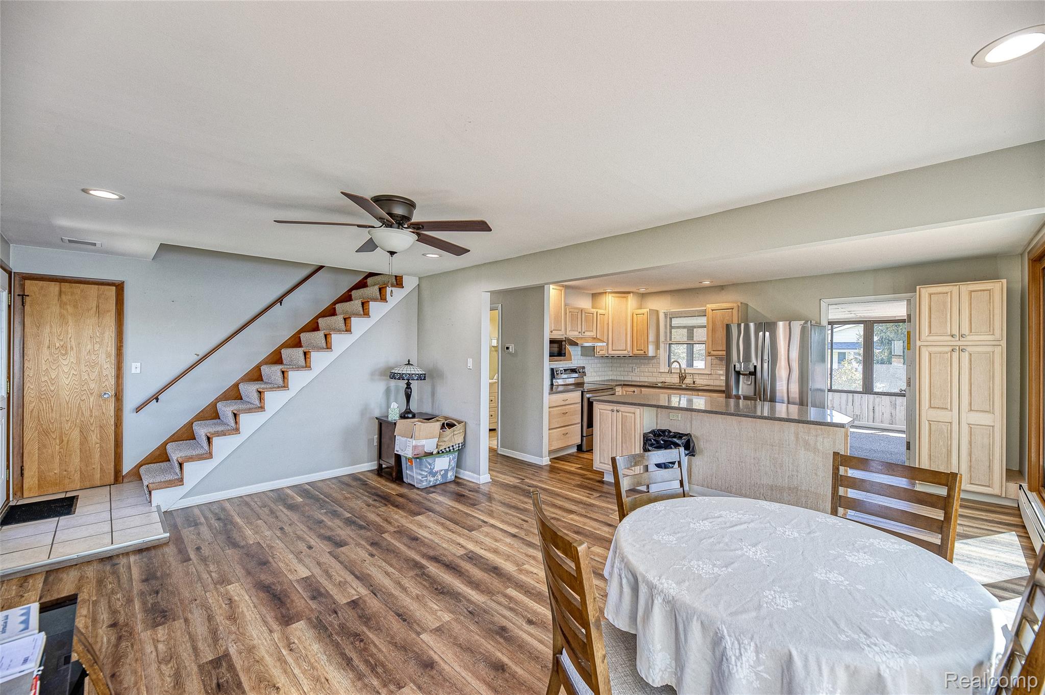 2855 Farmers Creek Road Metamora, MI 48455 - Photo 15 of 51 Open concept living area featuring wood-finish flooring, a contemporary ceiling fan, and a light wood staircase with carpeted treads