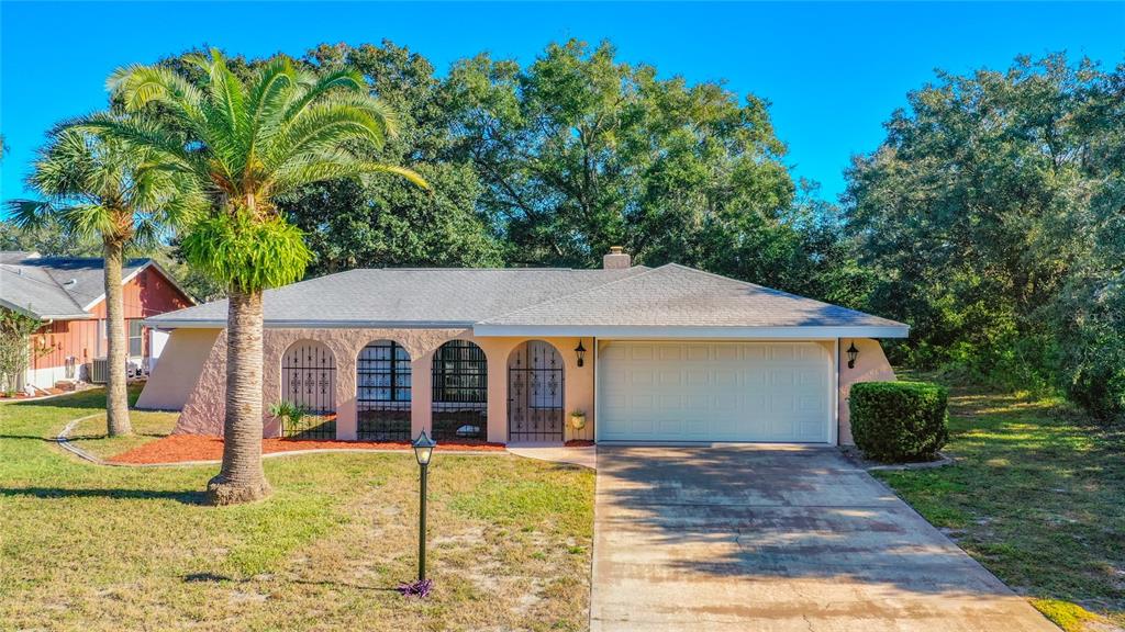 8311 Cofield Lane Spring Hill, FL 34608 - Photo 1 of 1 a view of a house with backyard porch and garden
