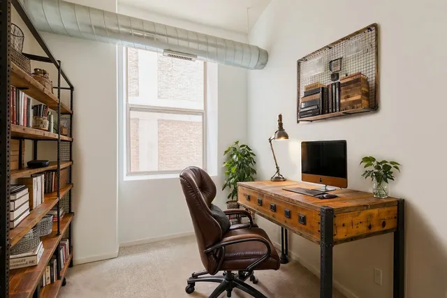 a view of a workspace with furniture and a bookshelf