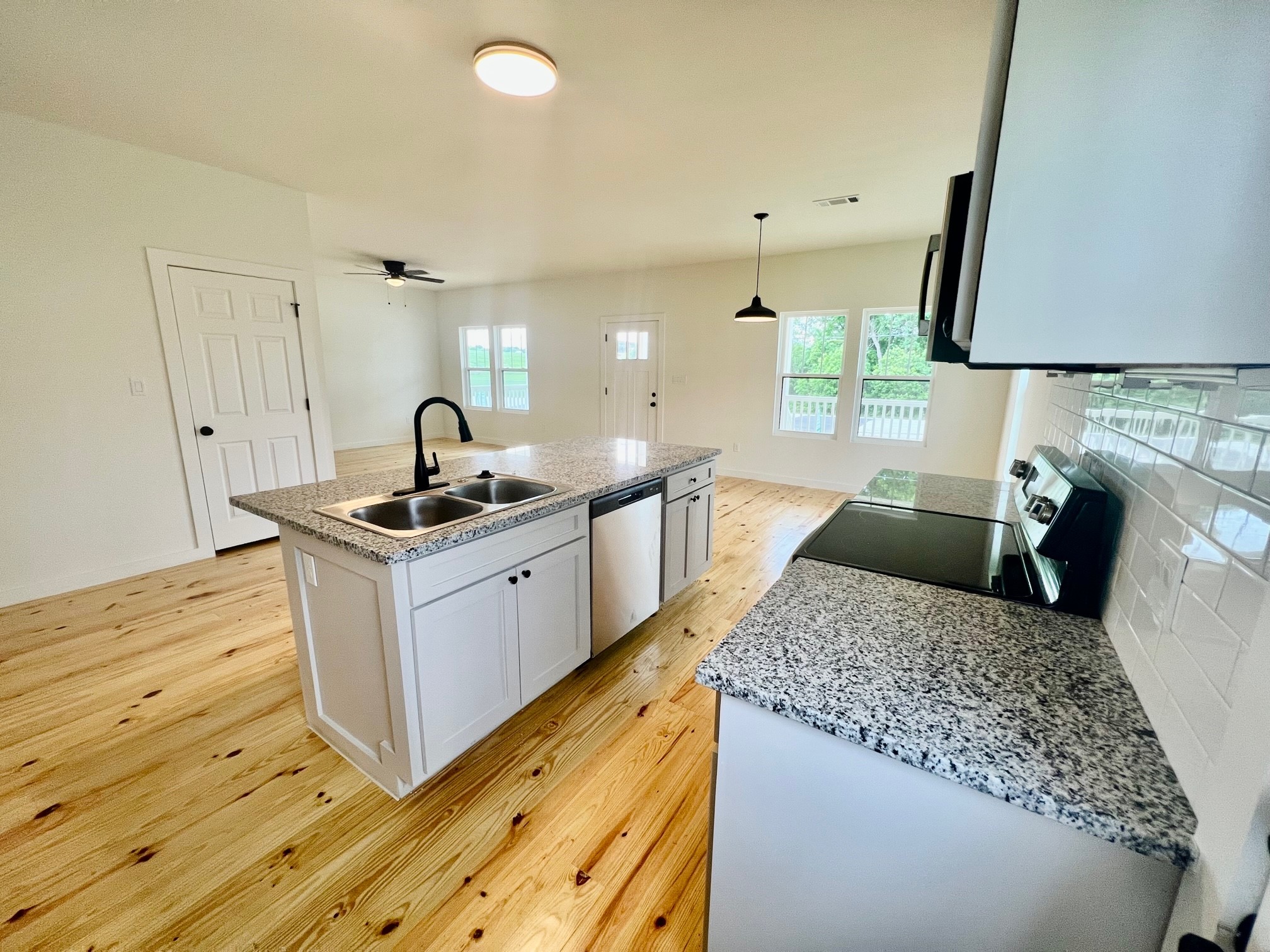 228 North Dixie Street Brenham, TX 77833 - Photo 3 of 10 a kitchen with granite countertop a sink stove and cabinets