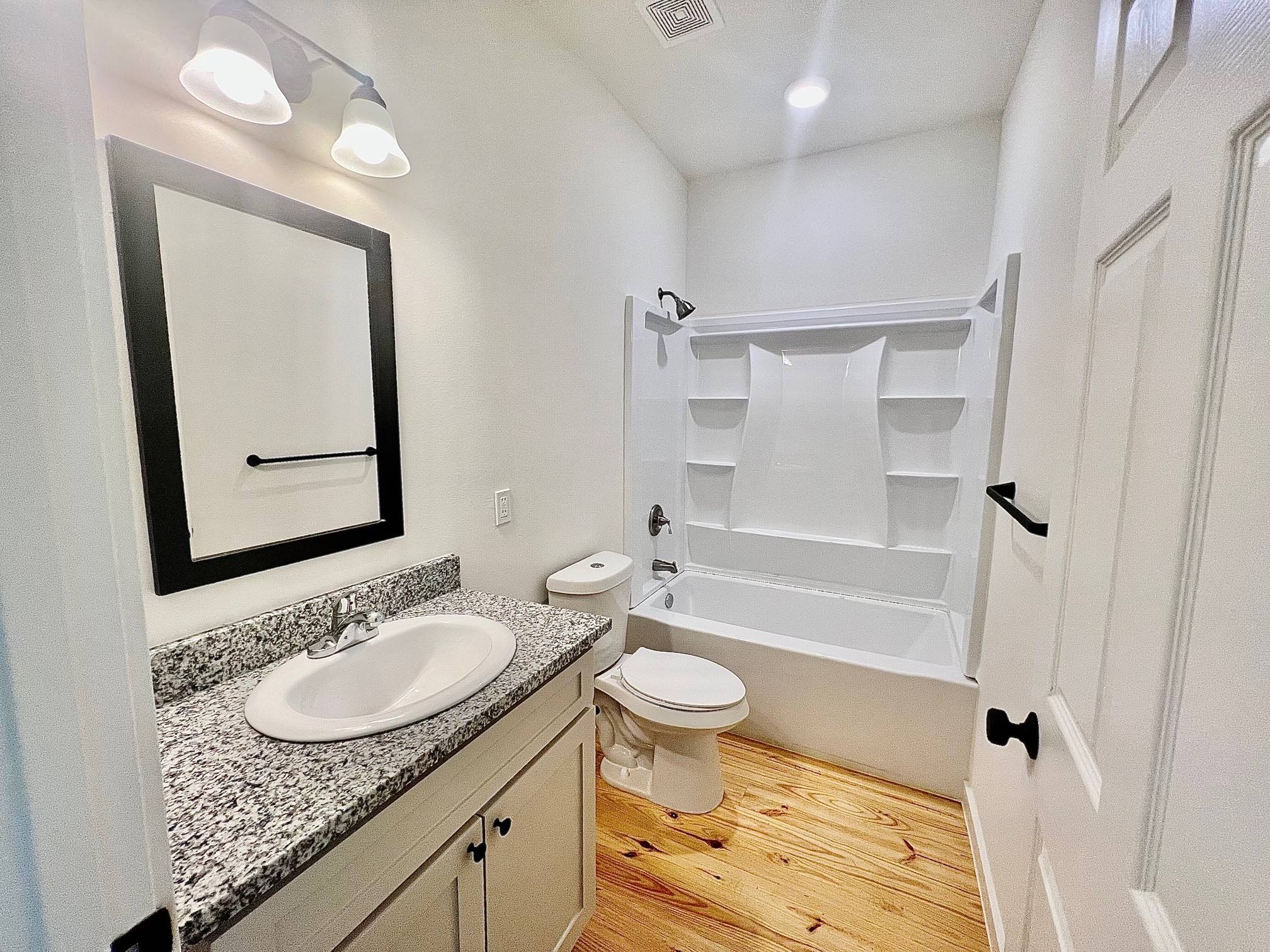 228 North Dixie Street Brenham, TX 77833 - Photo 7 of 10 a bathroom with a granite countertop sink toilet mirror and shower