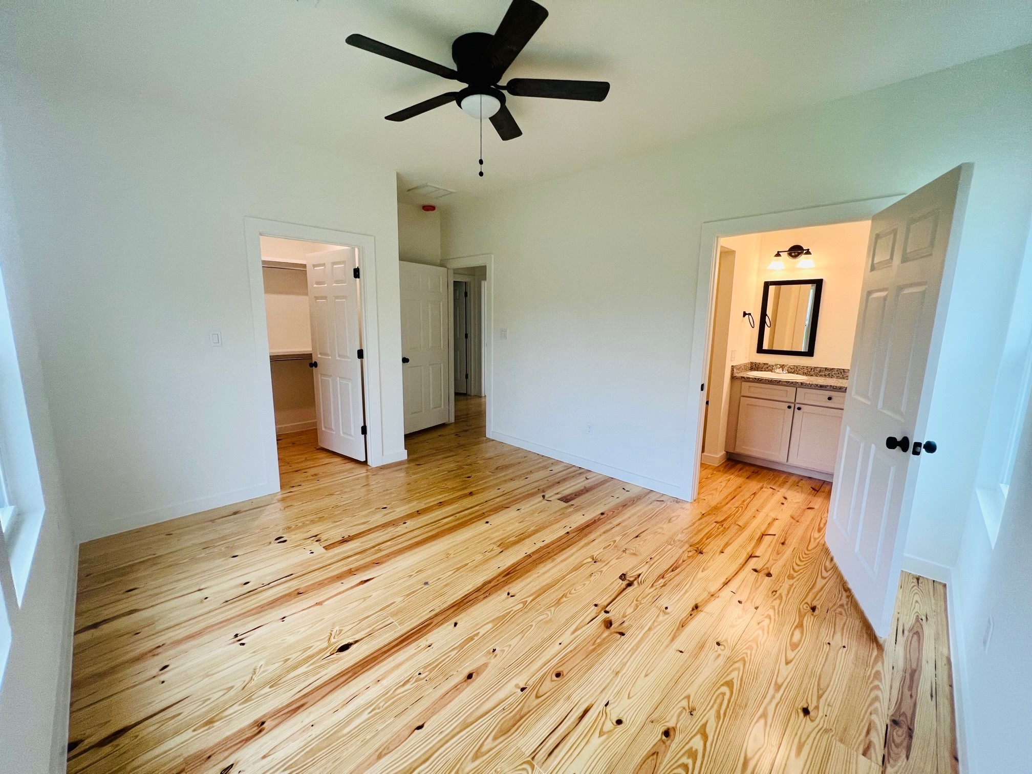 228 North Dixie Street Brenham, TX 77833 - Photo 8 of 10 a bedroom with a bed and wooden floor
