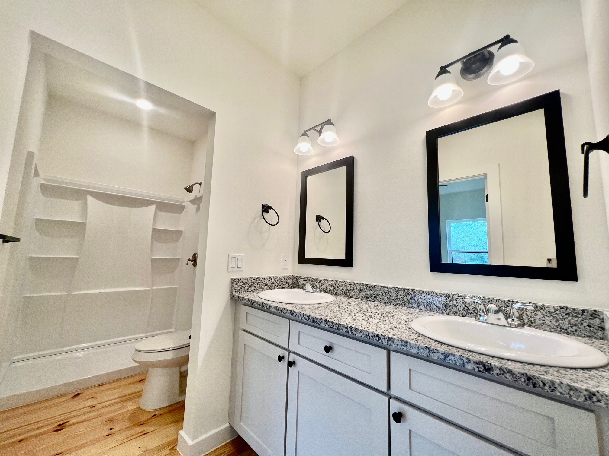 228 North Dixie Street Brenham, TX 77833 - Photo 9 of 10 a bathroom with a granite countertop toilet a sink and a mirror