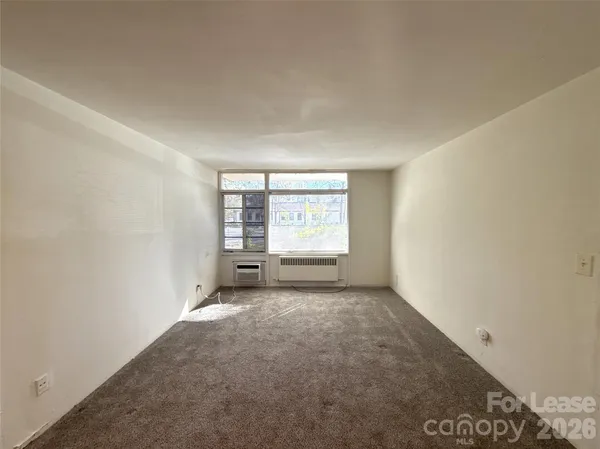 an empty room with furniture and a window