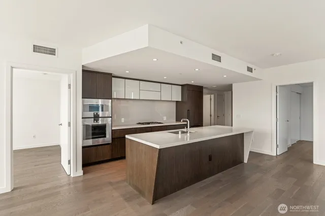 a kitchen with stainless steel appliances granite countertop a sink stove and refrigerator