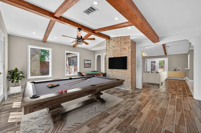 a living room with furniture a flat screen tv and a table