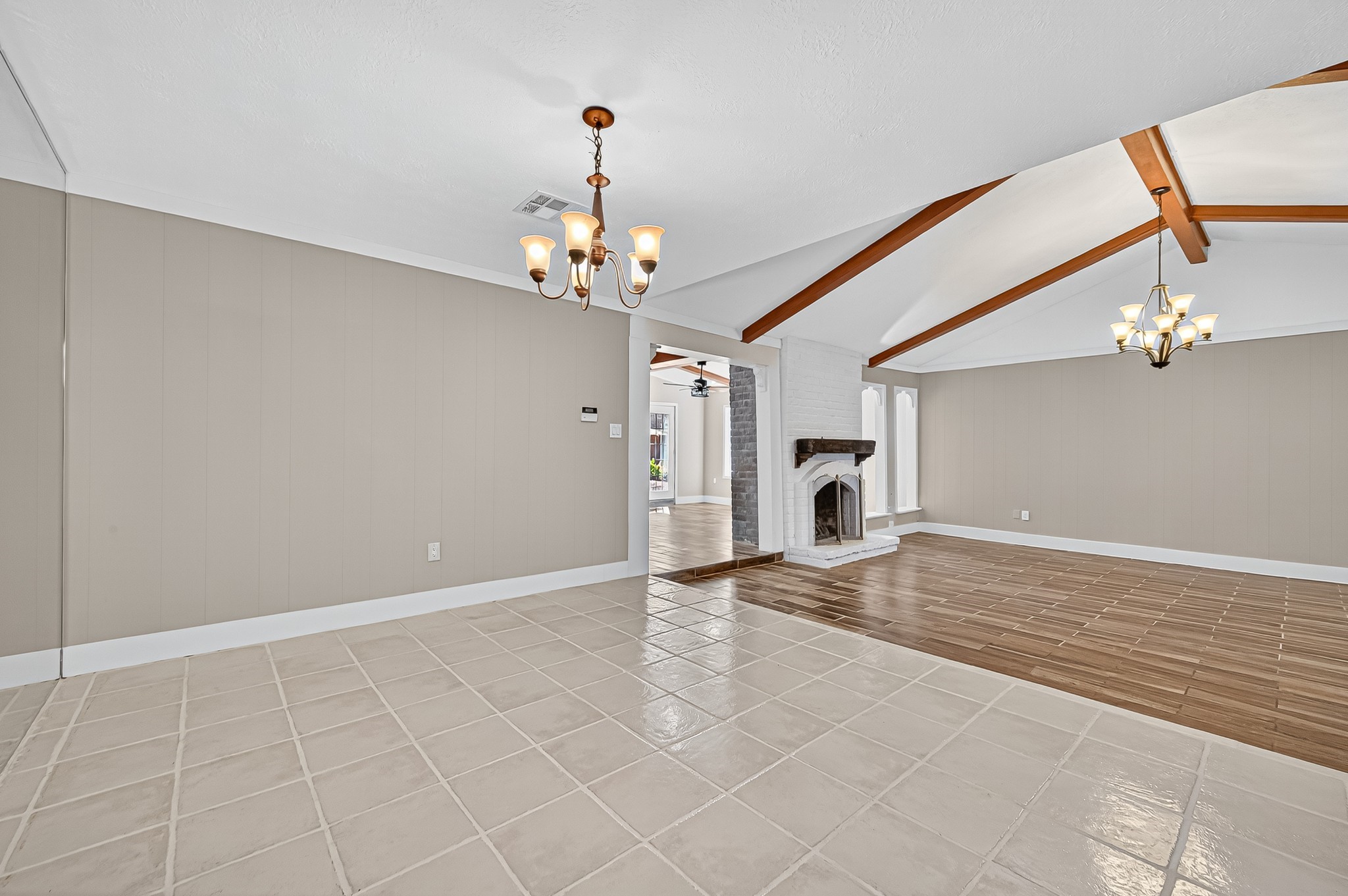 13903 Chevy Chase Drive Houston, TX 77077 - Photo 17 of 48 a view of a livingroom with a chandelier a kitchen area wooden floor fireplace and a chandelier