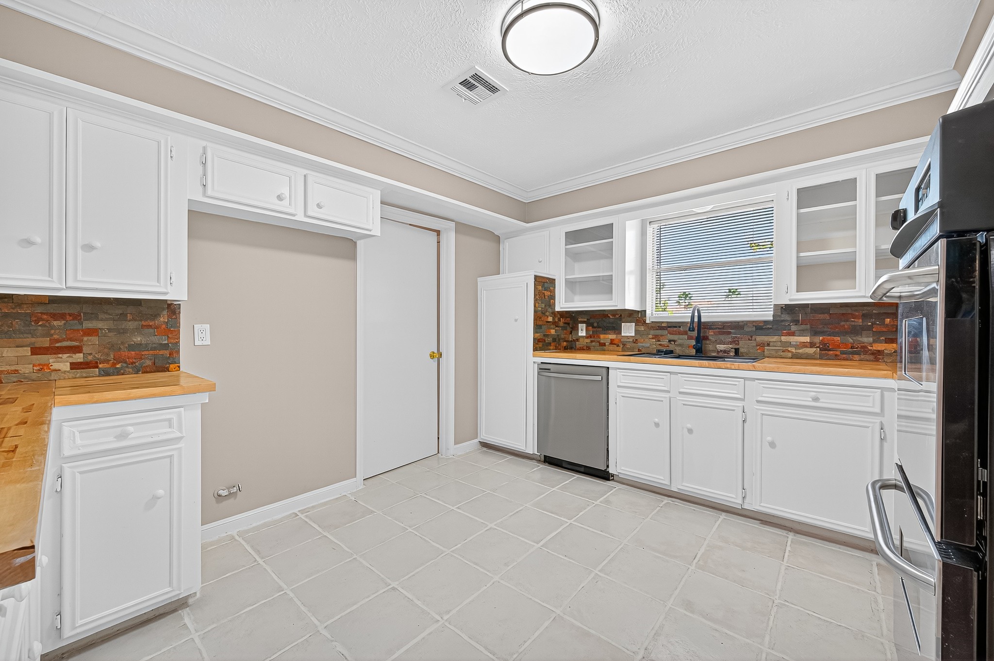 13903 Chevy Chase Drive Houston, TX 77077 - Photo 19 of 48 a kitchen with granite countertop white cabinets and white appliances