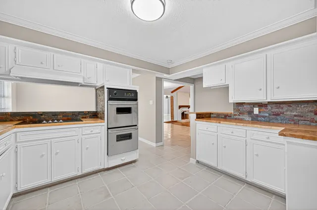a kitchen with granite countertop white cabinets and stainless steel appliances