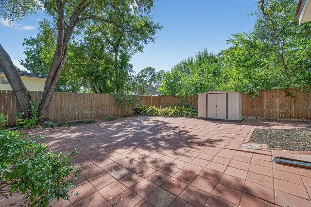 a view of a house with a yard and a large tree
