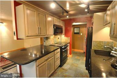 11607 Stoneview Square, Unit 2B Reston, VA 20191 - Photo 3 of 20 a kitchen with stainless steel appliances granite countertop a sink and cabinets
