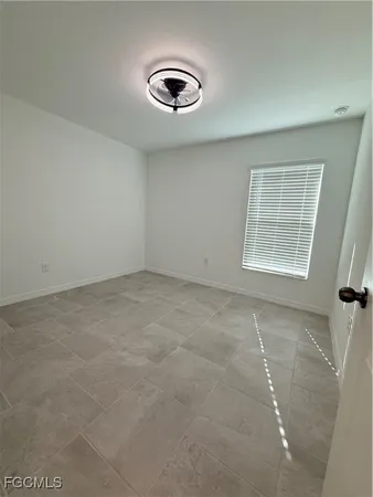 an empty room with windows and exposed radiator