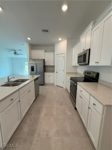a large kitchen with a large counter top appliances and cabinets
